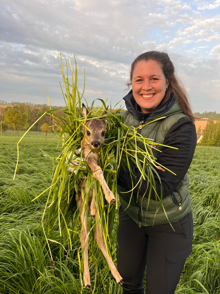 Kitzretterin hält Kitz in den Händen